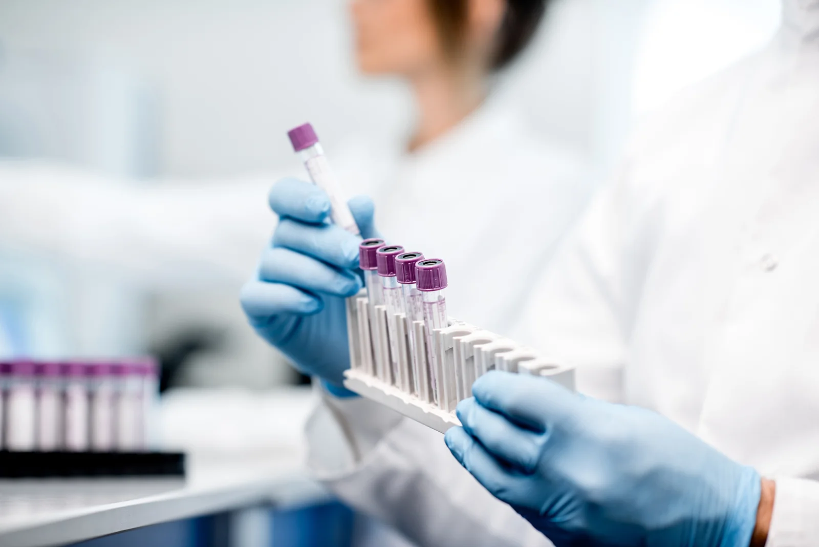 Laboratorioalan ammattilainen käsittelemässä näyteputkia